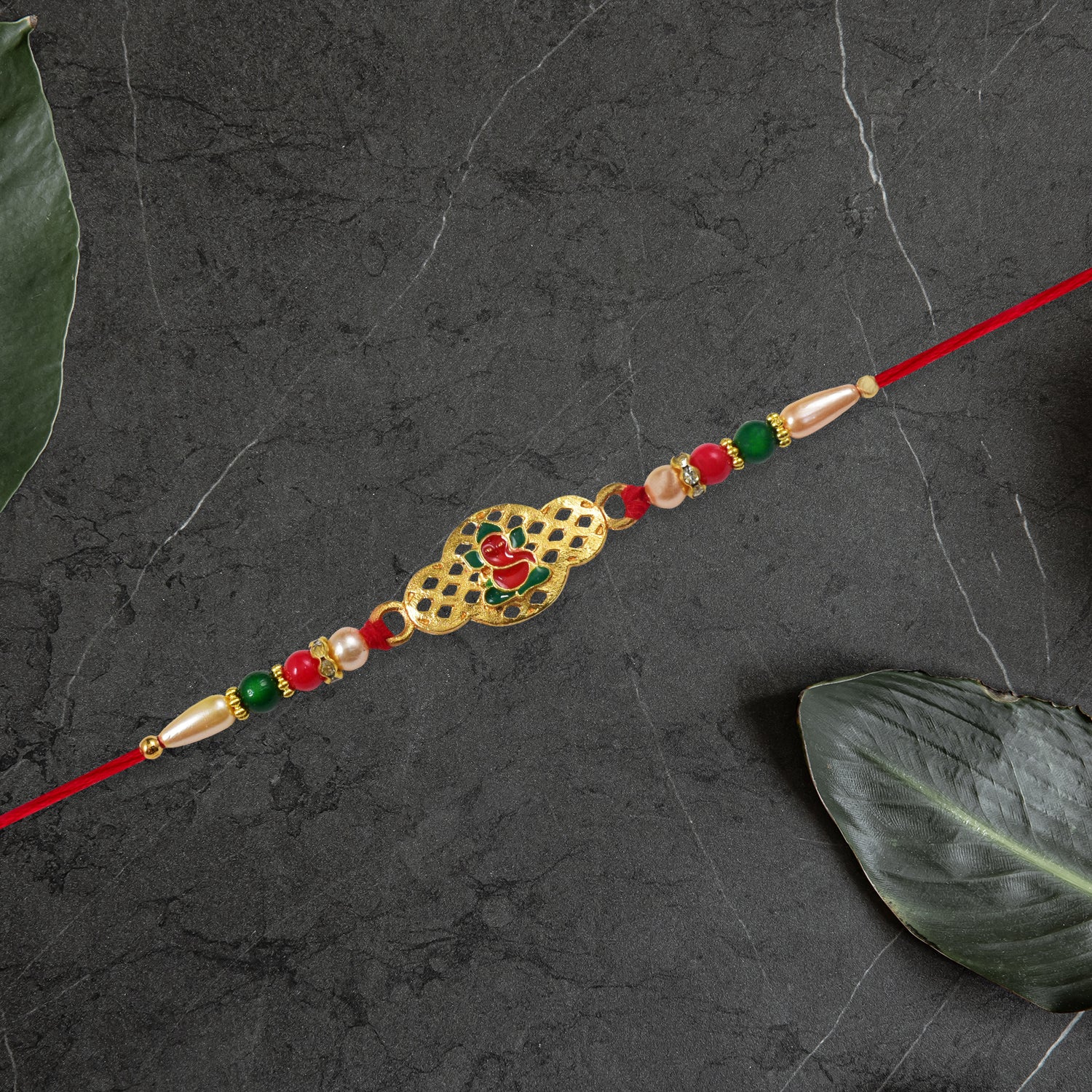 Religious Ganesha Rakhi In Gold Finish Religious Ganesha Rakhi In Gold Finish